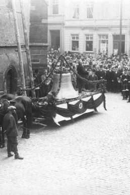 Geschmückte neue Glocke auf einem Pferdewagen vor der Kirche