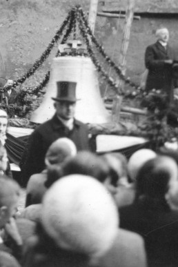 Geschmücke neue Glocke vor der Kirche