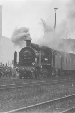 Personenzug mit Dampflokomotive im Bahnhof